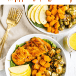 Two salad bowls topped with chicken breast, apple slices, and roasted Brussels and butternut squash. Two forks are off to the side. Text above reads Roasted Harvest Bowls with Apple Cider Dressing