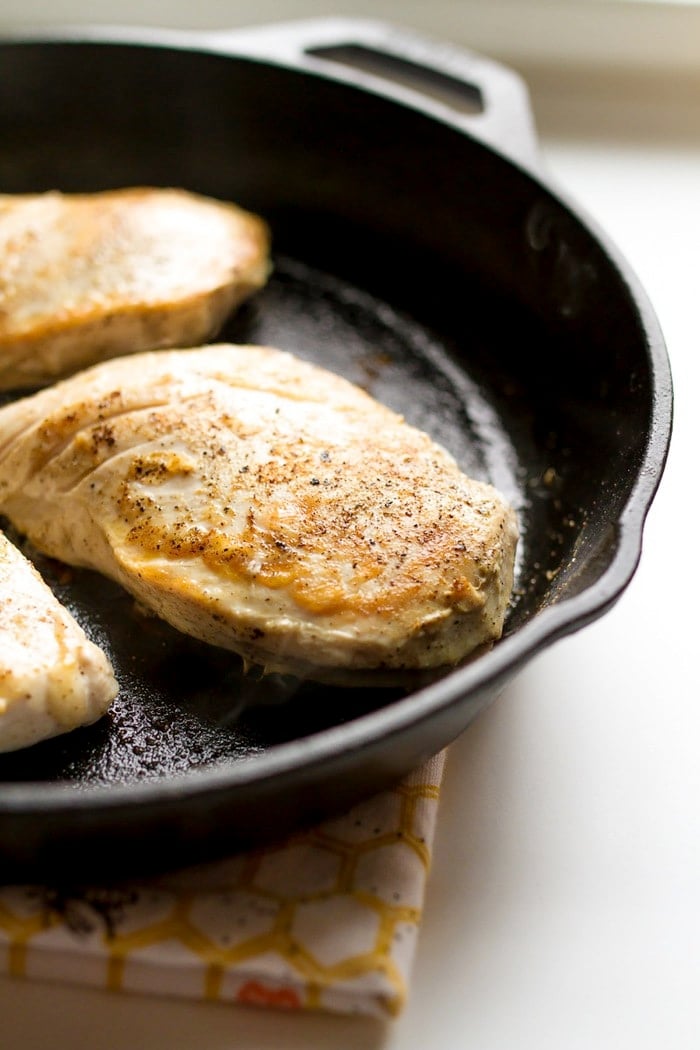 Maple turmeric chicken lightly seasoned in the cast iron skillet.