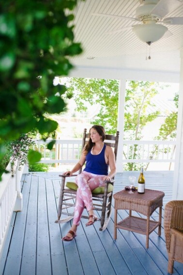 Woman in a rocking chair on a porch.