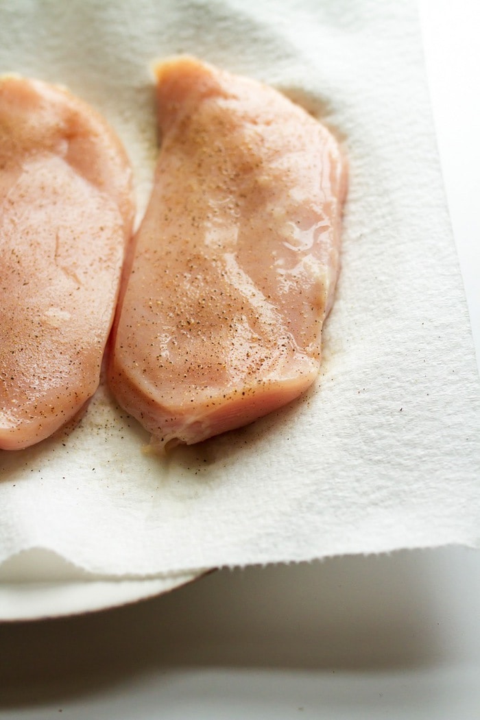 Raw chicken lightly seasoned with salt and pepper. 