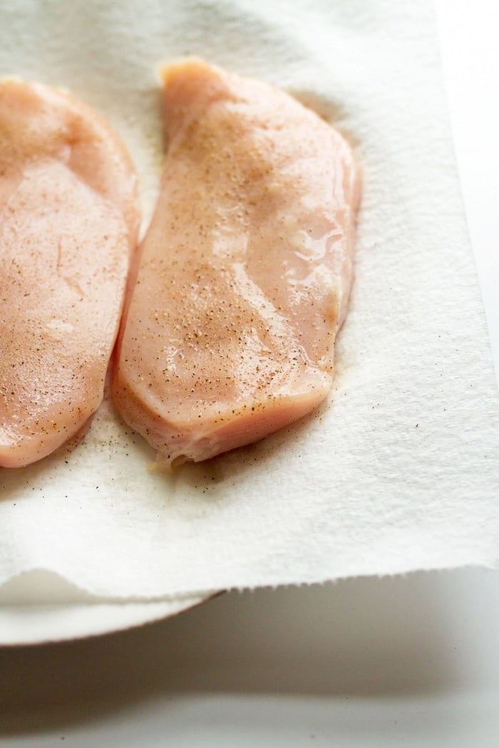 Raw chicken lightly seasoned with salt and pepper. 