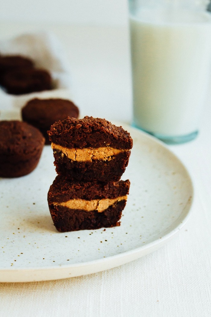 Almond Butter Stuffed Sweet Potato Brownie Bites on a large white platter, glass of milk in background.