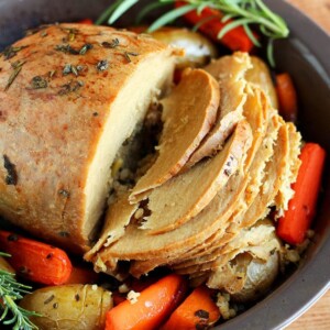 A close up of a Torfurky Roast surrounded by vegetables.