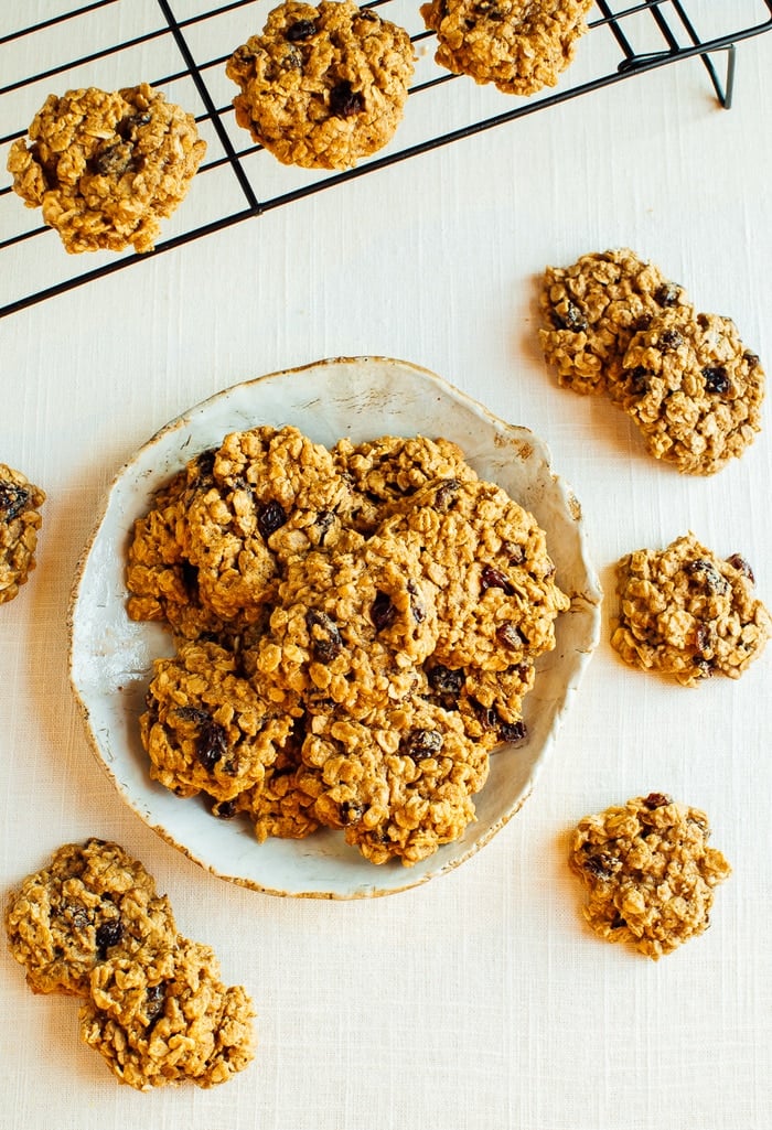 Dairy-free chewy oatmeal cookies sitting on a drying rack and plate