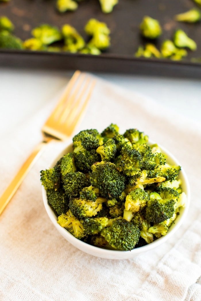 Roasted frozen broccoli in a bowl with gold fork. 