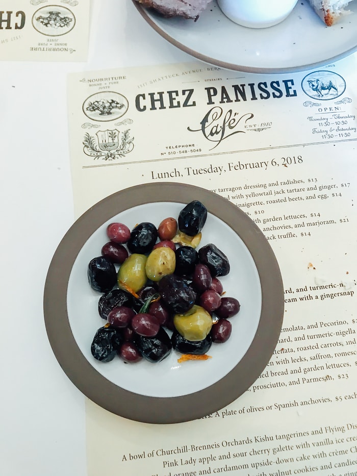 Bowl of mixed olives on a plate on a menu for Chez Panisse Cafe.