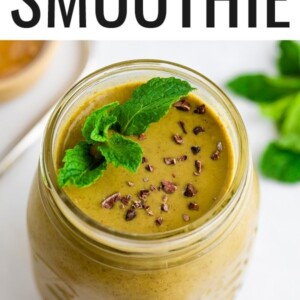 Mason jar with a mint chocolate chip smoothie garnished with cacao nibs and mint.