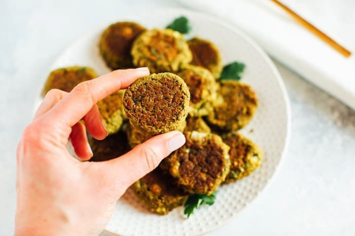 Small falafel patty held in a woman's hand