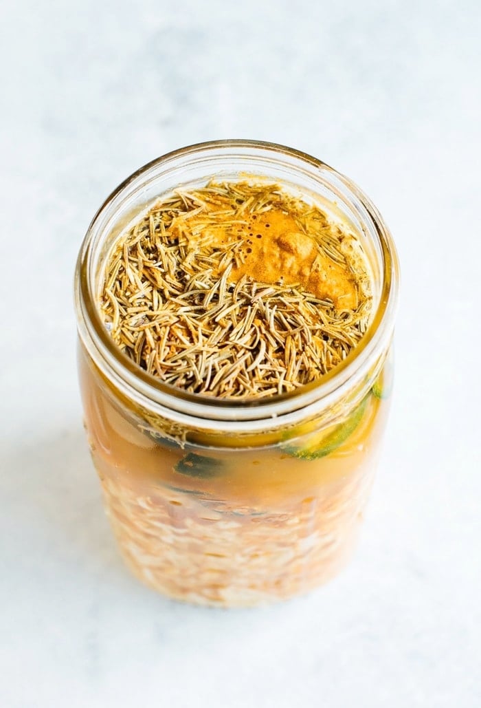 Fire cider in a mason jar with rosemary on top. Fire cider in a mason jar with rosemary on top.