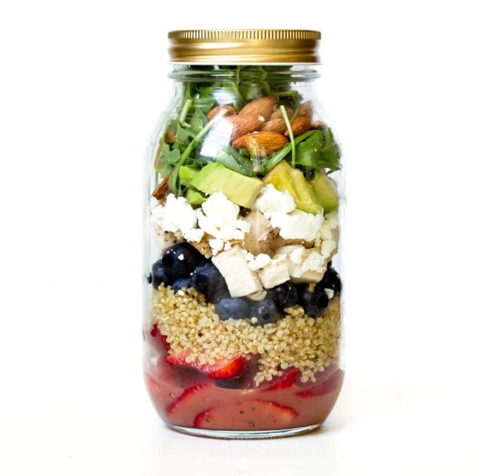 Balsamic chicken berry quinoa mason jar salad on a white background.