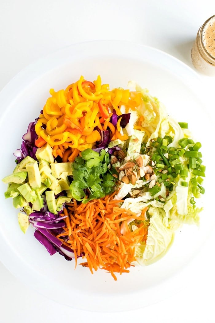 All the ingredients for an Asian chopped salad in a large salad chopper bowl. 