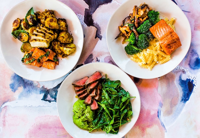 Overhead shot of three plates from Flower Child, a restaurant.