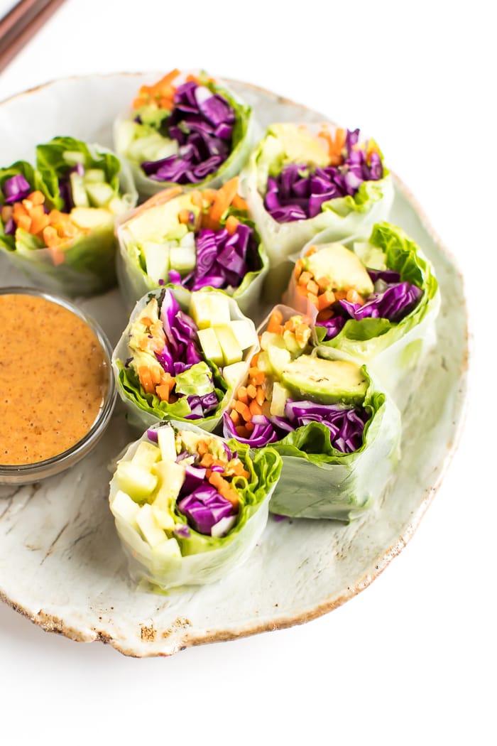Fresh vegetables spring rolls on a rustic plate with homemade peanut sauce. 