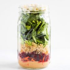 Mason jar salad with a zesty tahini dressing, beets, quinoa and goat cheese.