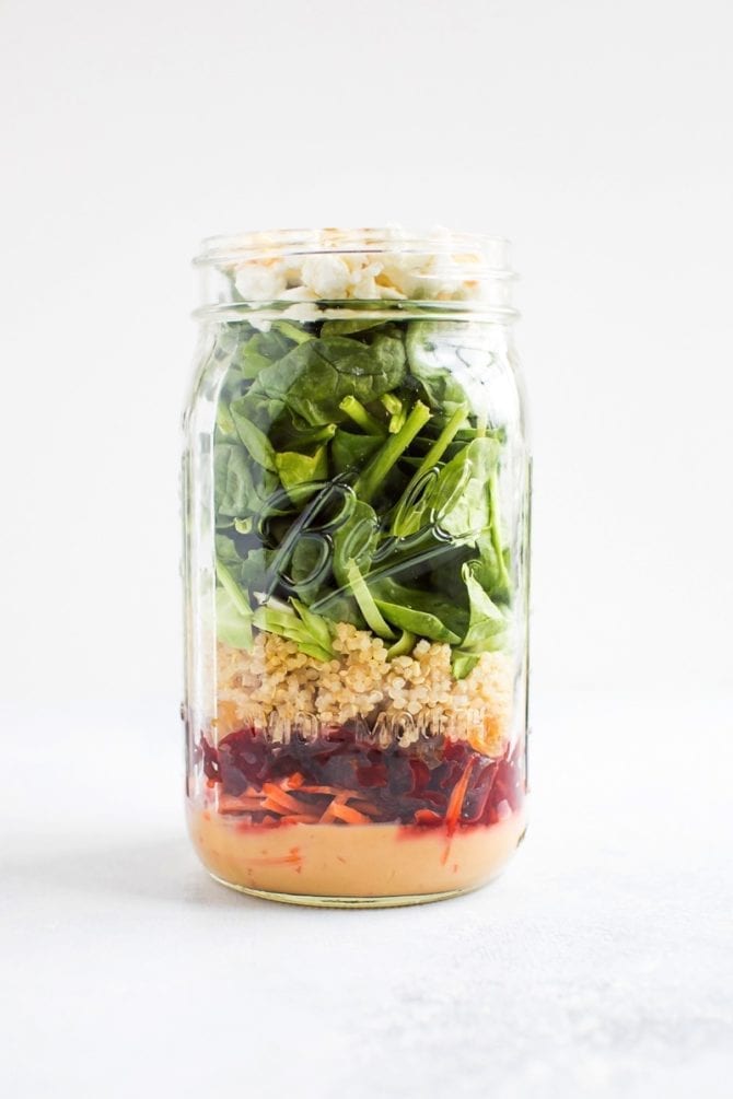 Mason jar salad with a zesty tahini dressing, beets, quinoa and goat cheese.