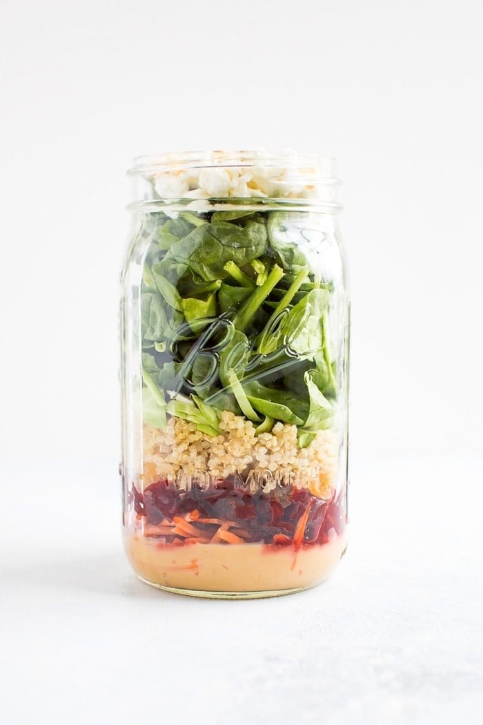 Mason jar salad with a zesty tahini dressing, beets, quinoa and goat cheese. 