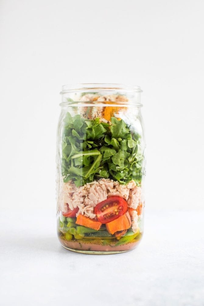 Layered nicoise salad in a mason jar.