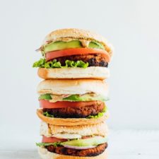 Stack of three tempeh burgers on buns.