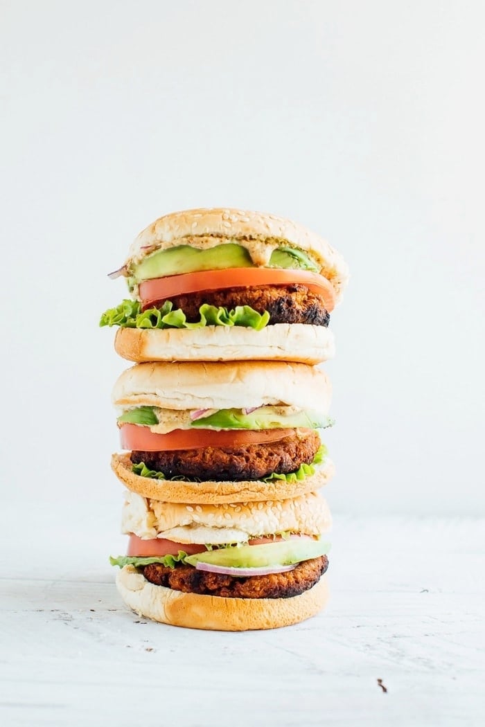 Three tempeh veggie burgers stacked. 