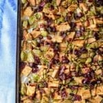 Sheet pan with baked garlic tofu and Brussels topped with pumpkin seeds and craisins.