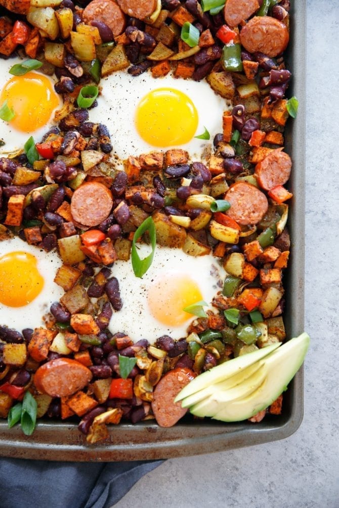 Sheet pan meal with chorizo, eggs, beans, avocado and onions.