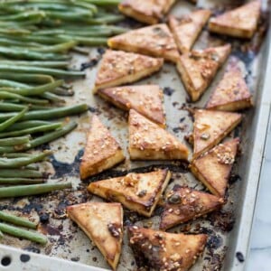 Sheet pan with baked spicy tofu and green beans.