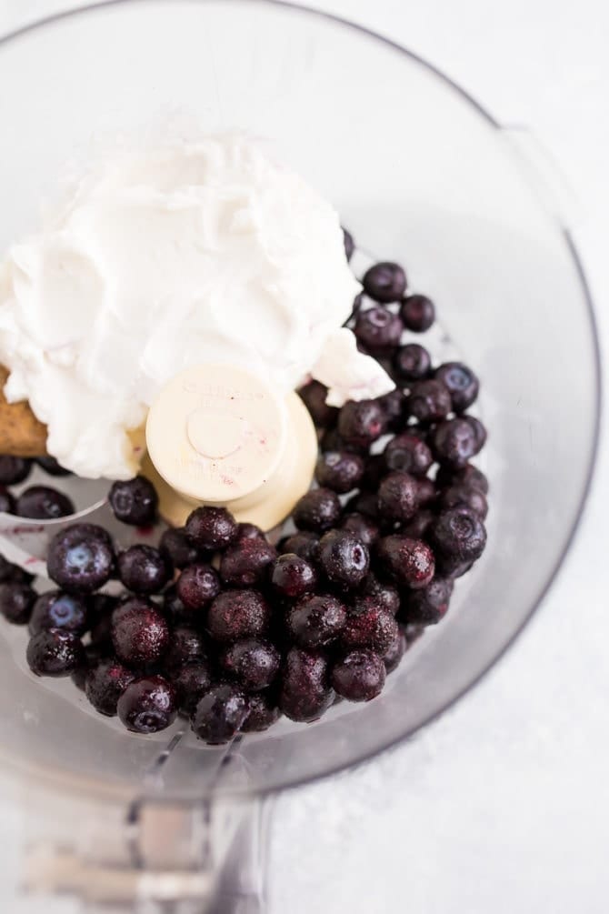 Food processed filled with yogurt, frozen blueberries and almond butter.