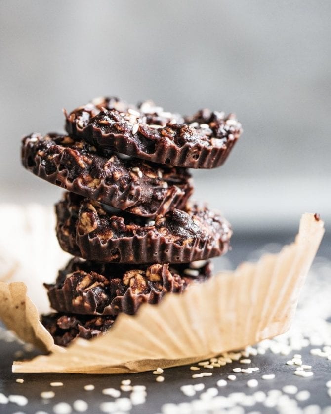 Dark Chocolate Tahini No-Bake Cookies. Cookies stacked on top of each other on a piece of parchment paper.