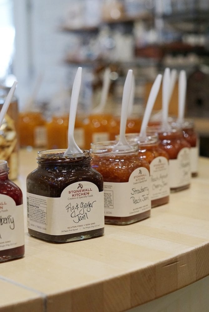 Jars of Stonewall Kitchen james lined up with spoons for sampling.