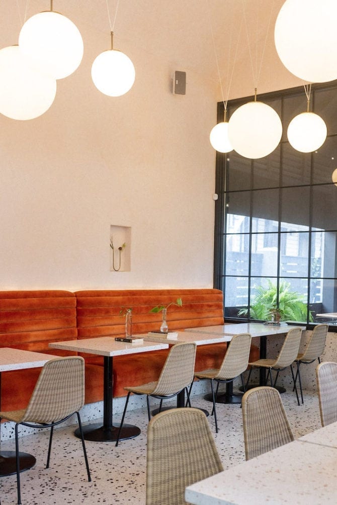 Interior of a restaurant in Charleston, SC. Booths on one wall and bulb lights having from the ceiling.