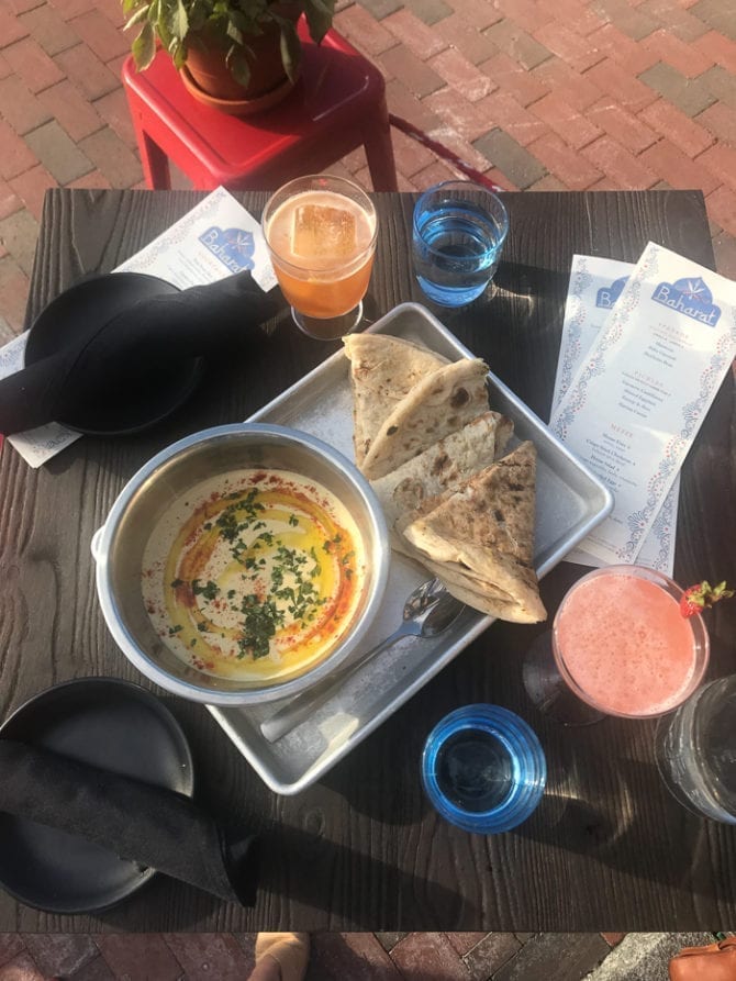 PIN THIS--> A Trip to York, ME and Portland, ME Table with drinks, water, and a plate of hummus and fresh pita bread.