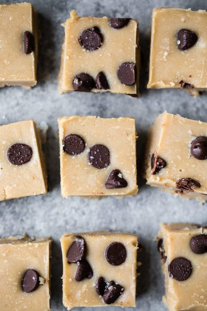 No Bake Salted Tahini Cookie Dough Fudge. Slices of fudge with chocolate chips laced out neatly on a table.
