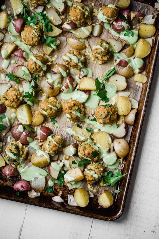 Paleo Turmeric Chicken Meatballs with Green Tahini Sauce on a baking sheet