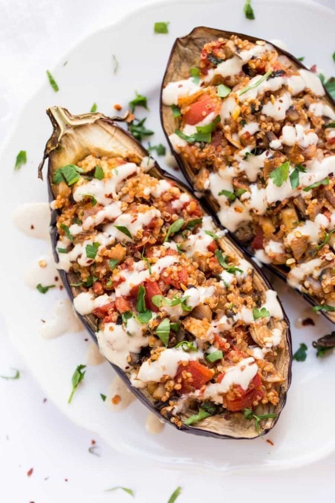 Quinoa Stuffed Eggplant with Tahini Sauce on a plate. (2 eggplant halves)