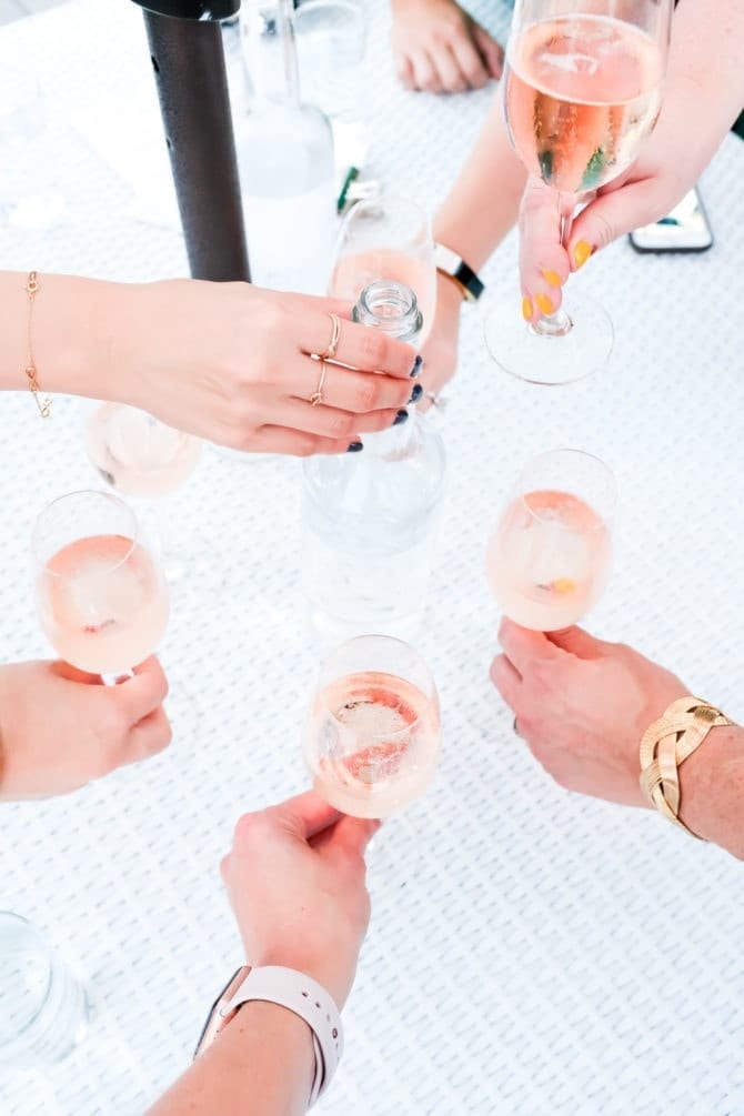 several ladies holding glasses of rose, cheersing