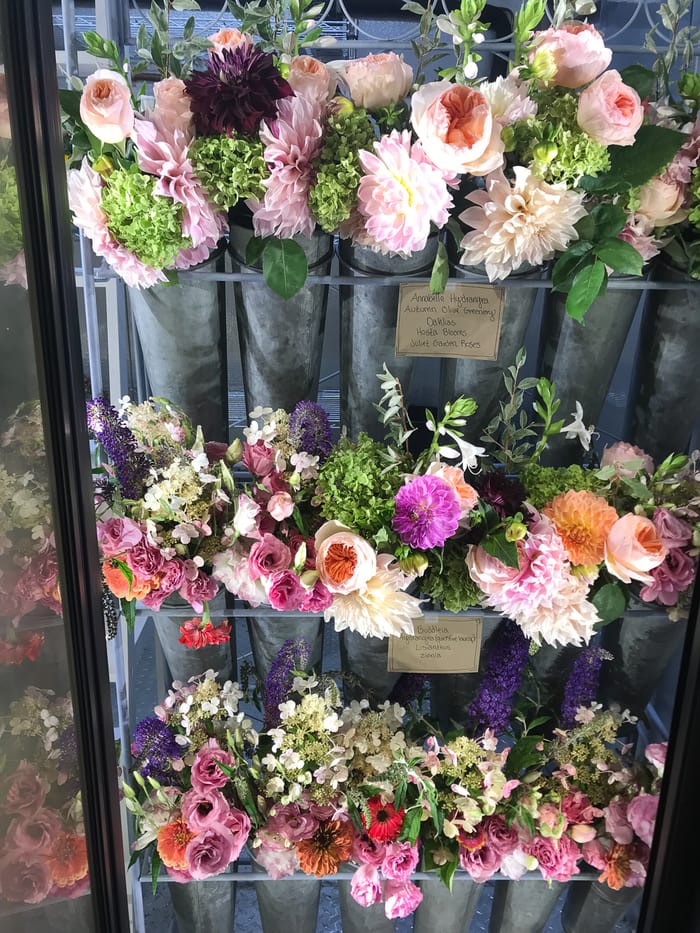 An open cooler filled with flower bouquets.