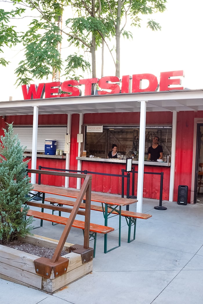 A restaurant with picnic tables outside and a walk-up ordering window. The sign on the roof says "Westside".