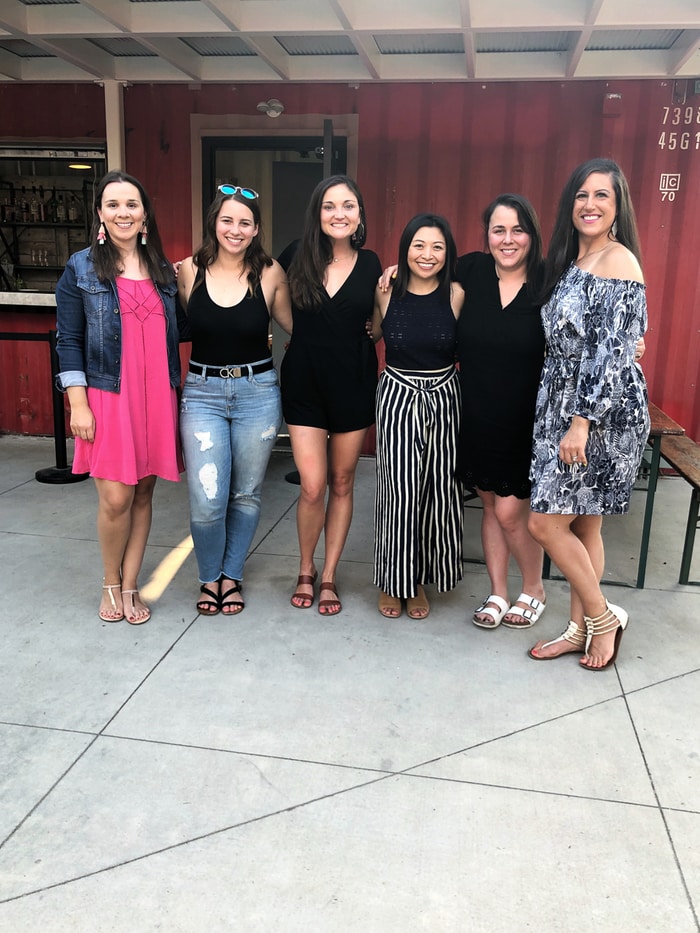 A group of 6 women standing in front of an outdoor restaurant 