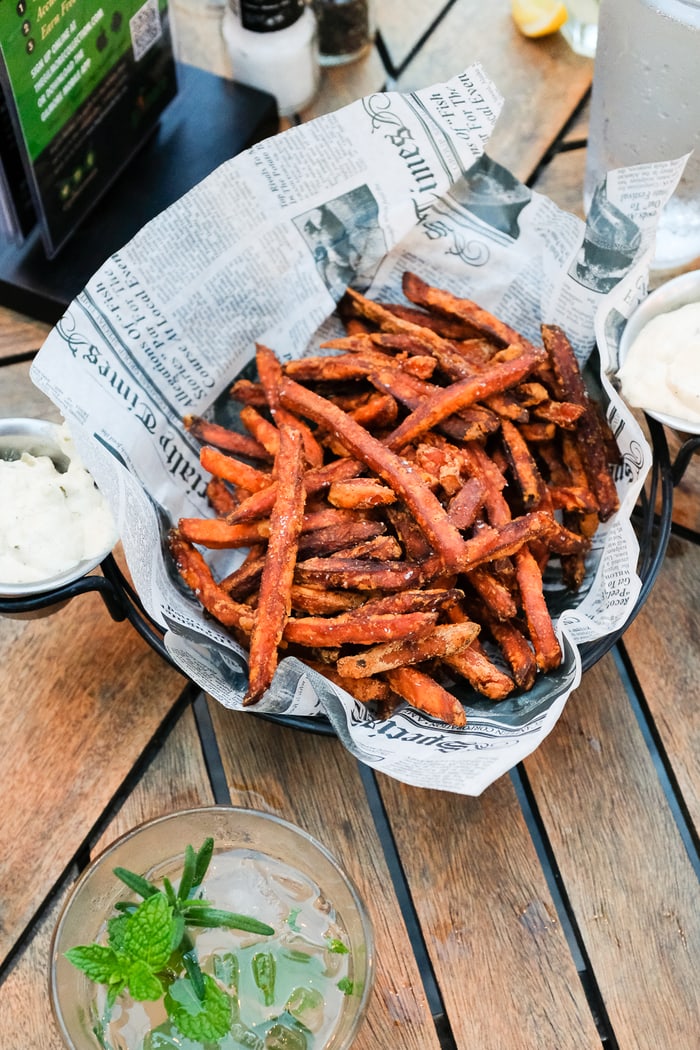 Basket of sweet potato fries in a newspaper lined basket.