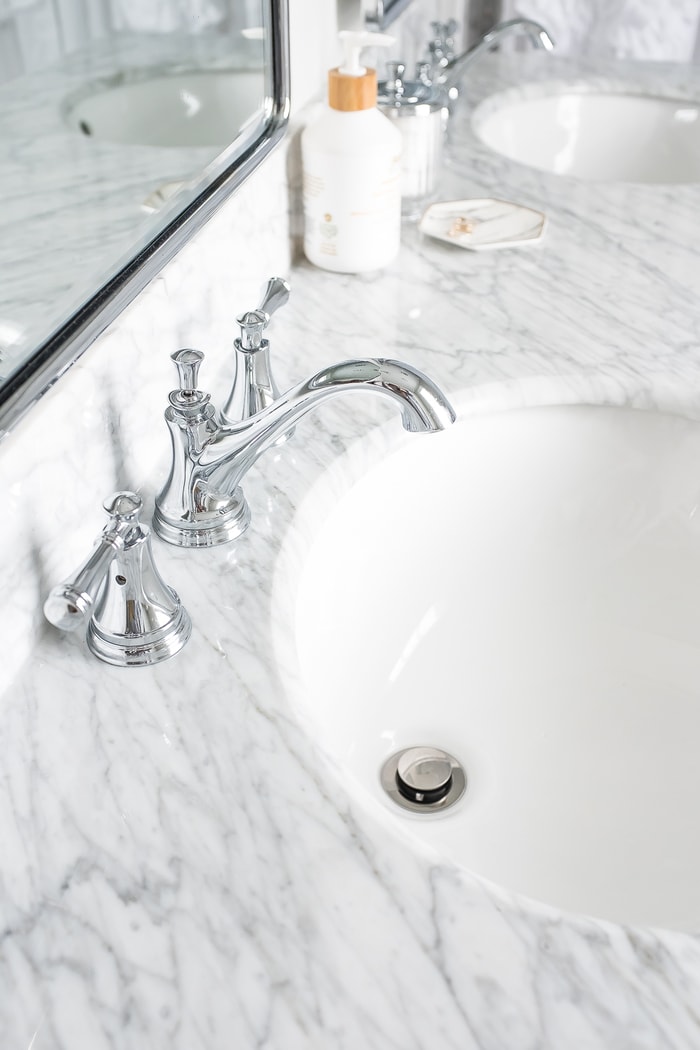 Renovated bright small bathroom with marble countertop.