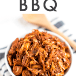 Bowl of jackfruit bbq on a folded, striped kitchen towel.