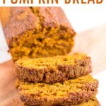Photo of homemade pumpkin bread with three slices of pumpkin bread taken out of it.