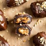 Medjool dates, pitted and split open with peanut butter and peanuts stuffed inside.