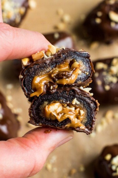 Chocolate covered peanut butter stuffed medjool date. Close up shot in between hands.