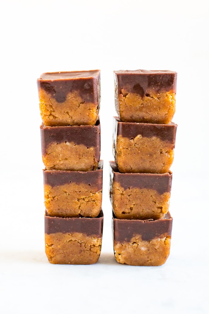 Two stacks of four collagen pumpkin fudge bites. They are cubes of pumpkin fudge topped with a layer of chocolate.