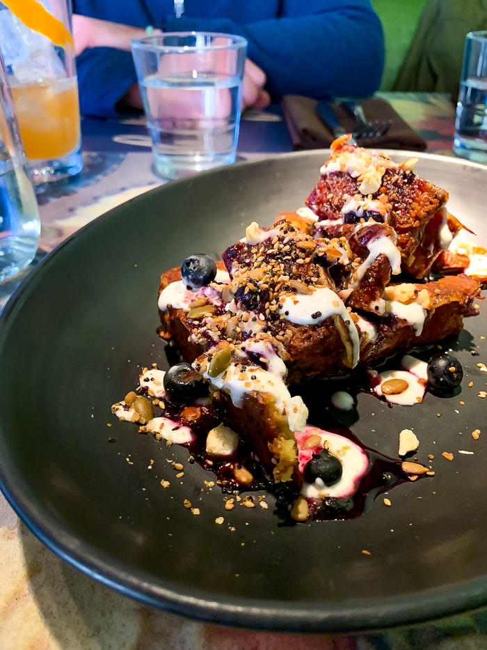 Zucchini bread French toast topped with seeds and berries.