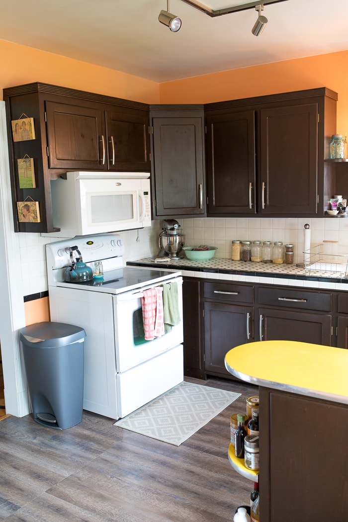 White stove and oven against brown wall cabinets. A yellow countertop protrudes from the bottom corner.