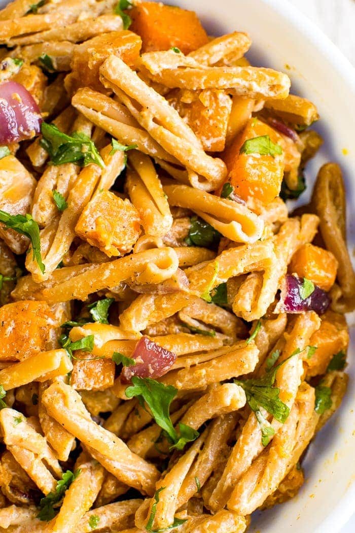 Bowl of roasted butternut squash pasta with tahini sauce.