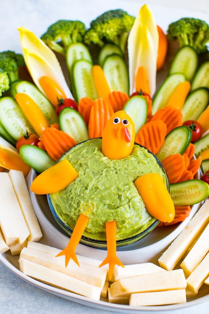 Cute turkey thanksgiving veggies tray. Veggies formed to look like a cute turkey as a veggie tray, with a bowl of guacamole.