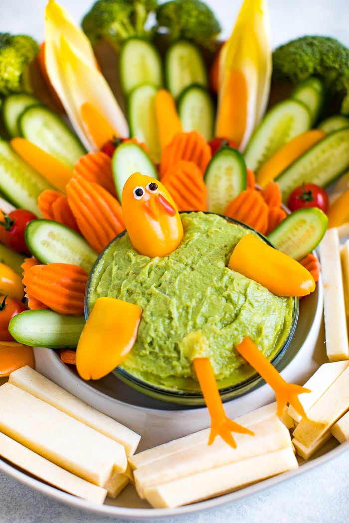 Cute turkey thanksgiving veggies tray. Veggies formed to look like a cute turkey as a veggie tray, with a bowl of guacamole.